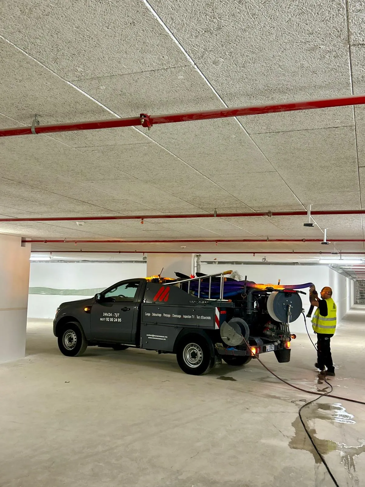 Véhicule équipé d'un dévidoir haute pression en parking souterrain