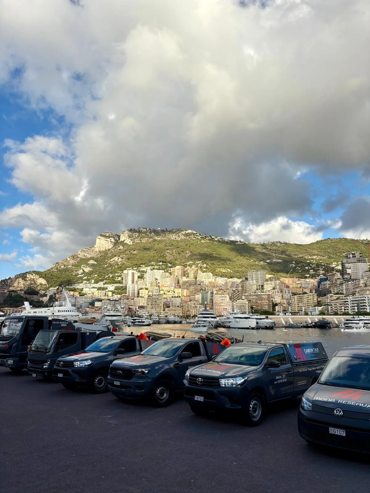 Pick-up et fourgons Mona Réseaux sur le quai, avec Monaco en arrière-plan